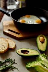Healthy breakfast: scrambled eggs, toast, avocado, lettuce, rosemary

