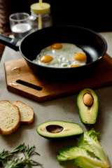 Healthy breakfast: scrambled eggs, toast, avocado, lettuce, rosemary
