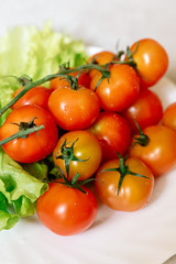 Cherry tomatoes with lettuce on a gray background
