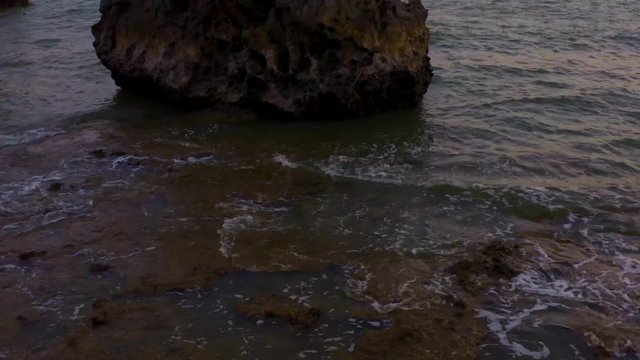 Sunset drone shot between rocks in the ocean in Thailand