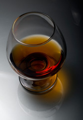 Cognac in a glass. Wine in a glass. Cognac in the dark key. Noble alcohol. Port in a glass on the table.