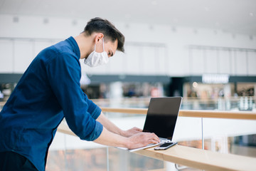 close up. a young man in a protective mask using a laptop