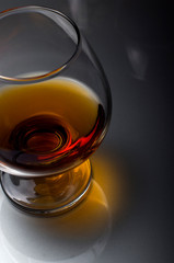Cognac in a glass. Wine in a glass. Cognac in the dark key. Noble alcohol. Port in a glass on the table.