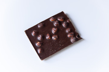 A bar of milk chocolate with hazelnuts on a white background