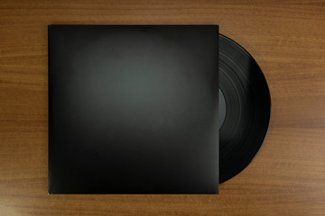 Empty Black Vinyl disk case and vinyl in a wood background for mockup purposes