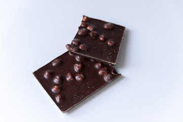 A bar of milk chocolate with hazelnuts on a white background