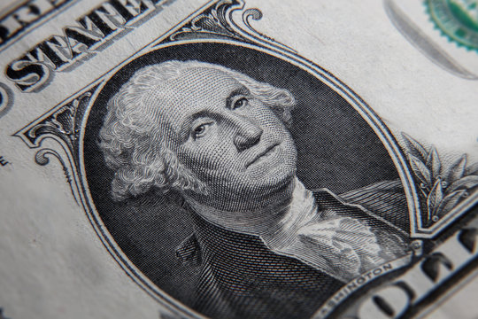 Macro photography of a 1 US dollar banknote. Close up of a one American dollar note. US dollar is the world currency.  The portrait of George Washington, the first president of the United States. 