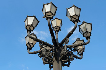 Fototapeta na wymiar Closeup of a historic street lamp with nine Schinkellampen (lamps designed by Karl Friedrich Schinkel) on the Gendarmenmarkt between the German and the French cathedral, Berlin, Germany, Europe 