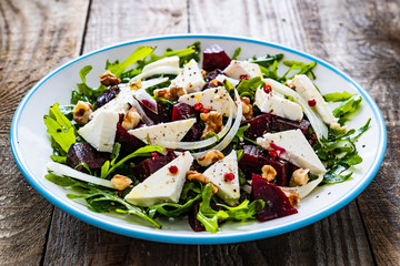  Beetroot salad with feta cheese on wooden table
