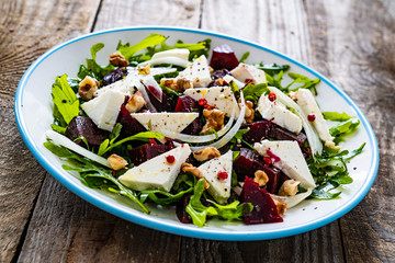  Beetroot salad with feta cheese on wooden table
