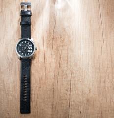 Black modern watch on wooden table