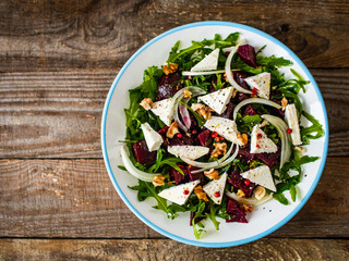  Beetroot salad with feta cheese on wooden table
