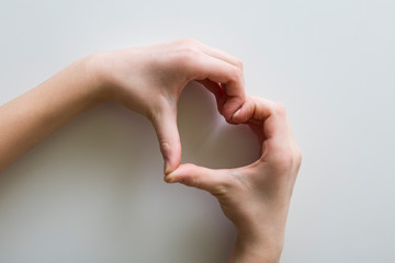 mani che unite assieme formano il segno del cuore