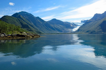 View of the beautiful mountain landscape reflecting in the Holandfjord near Svartisenvasnet - Svartisen Lake in front of the Engabreen glacier, Norway, Europe
