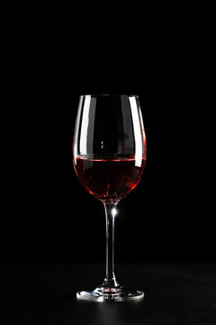 A glass of red wine in dark background