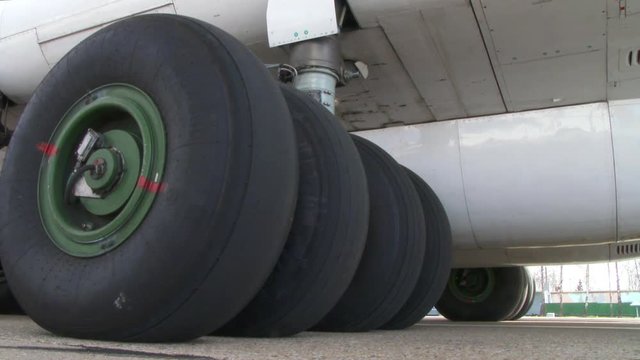 Close up worn tires of a passenger plane at the airfield. shot of the chassis of a large passenger liner from the outside of the mechanism. large wheels of an airplane standing on the runway 4k