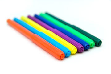 Colorful markers lying in a row on a white background. Art and education.
