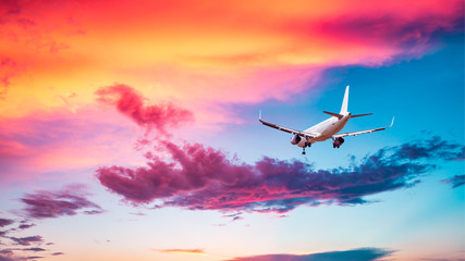 Commercial airplane flying in beautiful sky at sunset,travel concept.
