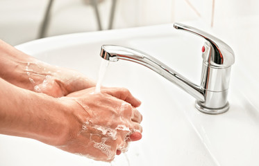 Man washing hands under water tap faucet. Personal hygiene concept, can be used during covid-19...