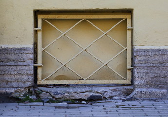 A basement window with a metal barrier