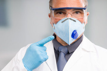 Doctor in medical gloves points to his profesional medical face mask