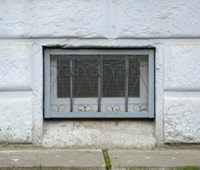 Fototapeta na wymiar A basement window with a metal barrier
