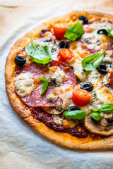 Pizza with pepperoni gorgonzola and champignons  on baking paper 