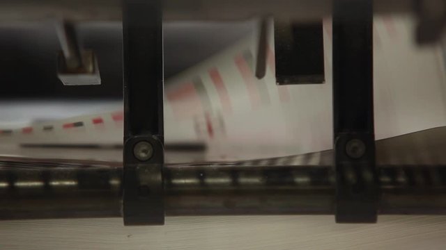 Industrial precise machine in working process of offset printing press.Close up.