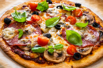 Pizza with pepperoni gorgonzola and champignons  on baking paper 