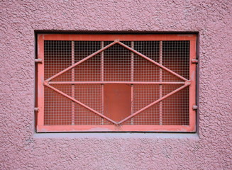 A basement window with a metal barrier