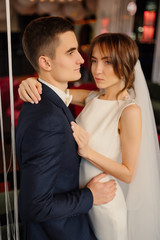 Obraz premium Elegant newlyweds at a photo shoot in a modern interior. Wedding, love, relationship concept.