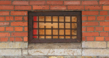 A basement window with a metal barrier