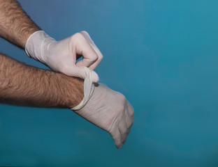 hands with the protection worms on a blue background, holding some test tubes to analyze the...