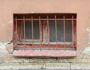 A basement window with a metal barrier
