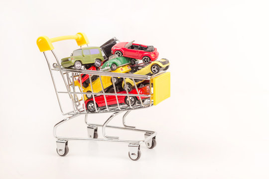 Mini shopping cart with mini cars on color background