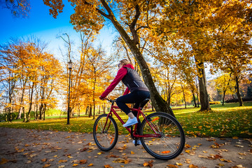 Urban biking - woman riding bike in city park