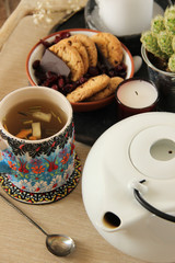 Afternoon tea ceremony arrangement. Tea time set with a selective focus. White tea pot and cute tea mug.