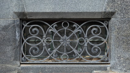 A basement window with a metal barrier