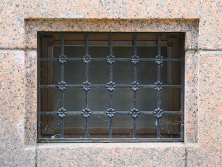 A basement window with a metal barrier