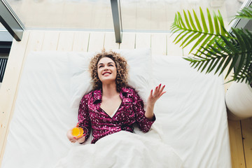 Woman on Hotel Bed Covering Self With Sheet.