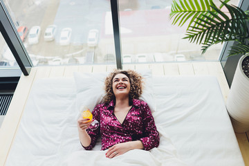 Woman on Hotel Bed Covering Self With Sheet.
