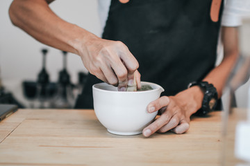 A brush made of bamboo and a teacup with green tea called matcha on wooden tray made by professional barista in Asian cafe.Green tea powder being stir in a white ceramic bowl.Tea ceremony in oriental 