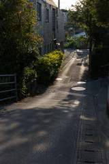 日差しが道路を照らす路地裏