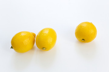 three yellow fresh lemons isolated on white table  healthy energy drink  concept