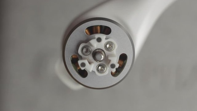 Macro shot top down brushless motor. Preparing a drone before flight, removing propellers and checking motor.