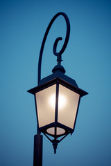 Fototapeta na wymiar Antique street lamp lit outdoors at night