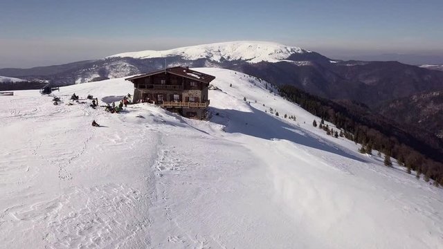 Heliskiing Around The Beautiful Snow-Capped Mountain With A Little Cabin Nestling On It At Muntele Mic In Carpathians, Romania - Drone