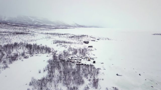 A Small Village Near A Lake Totally Frozen During Winter In Abisko, Sweden - Drone (backward)