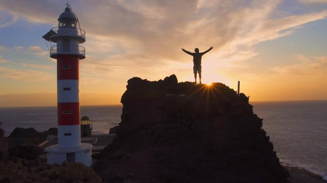 A young man at sunset in the lighthouse of Punta de Teno, Tenerife