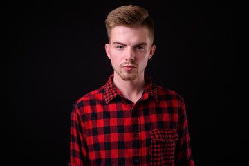 Portrait of young handsome blond bearded hipster man